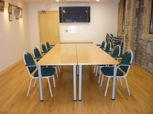 Photo of Bradbury Meeting Room showing tables and flat screen TV
